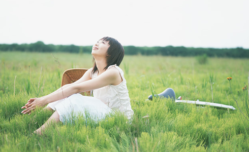草むらに座る女性の写真