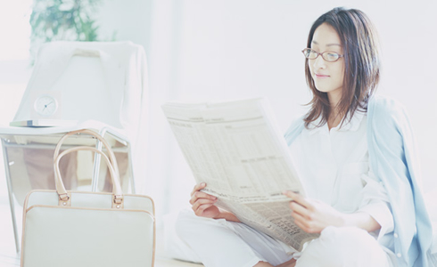 新聞を読む女性の写真
