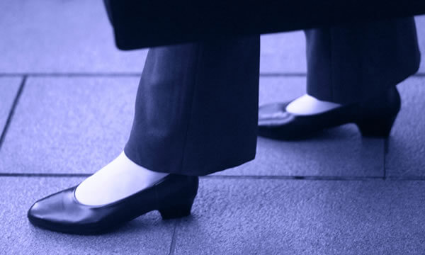 スーツで早歩きをする女性の画像