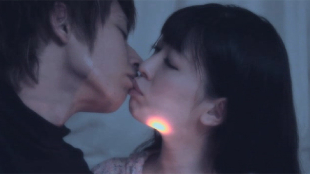 顔を懐中電灯で照らされながら男性にキスされる女性