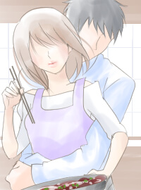 料理中の女性を後ろから抱き締める男性