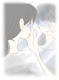 くすんだ顔を鏡で見つめる女性